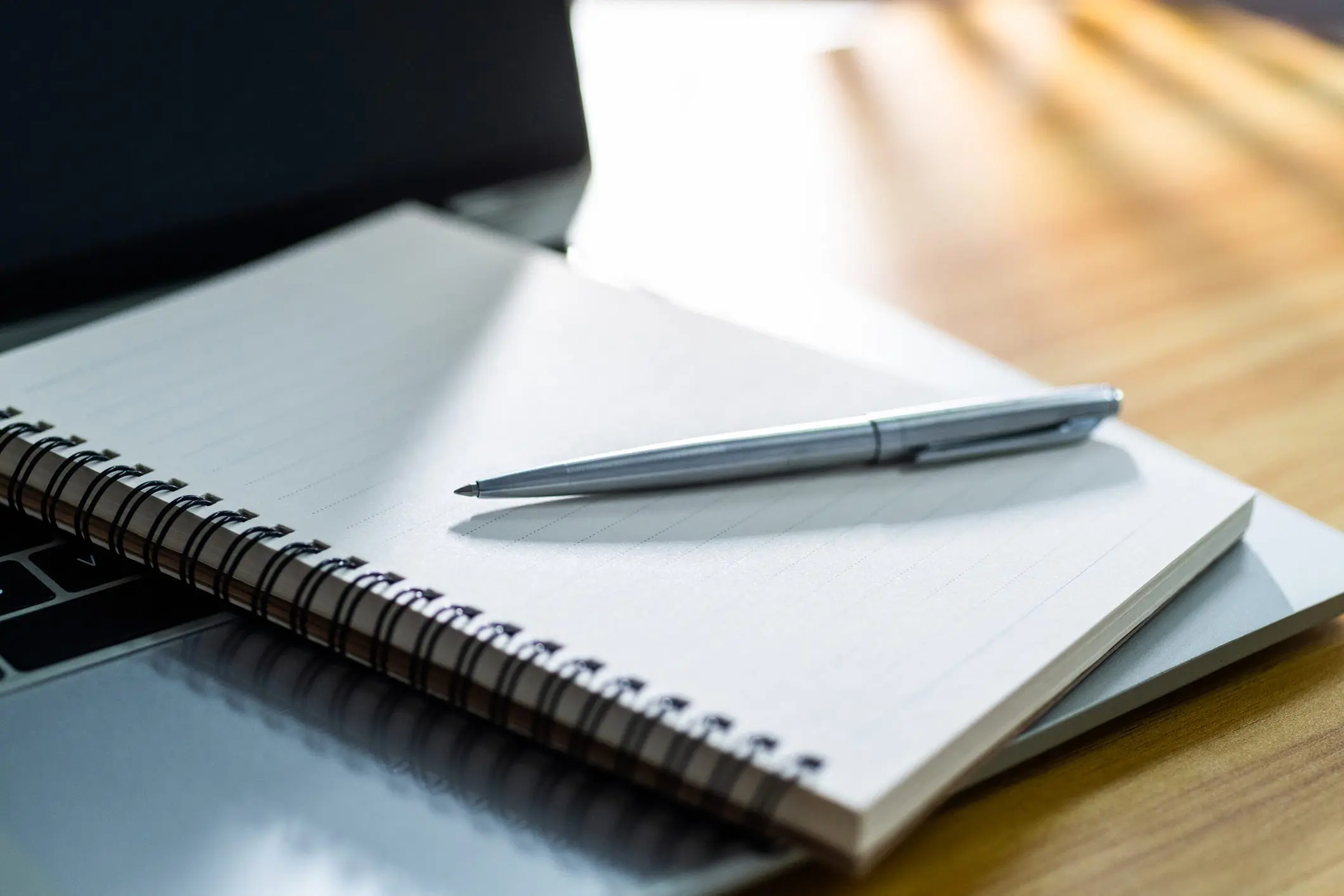 Notebook and pen on a laptop.